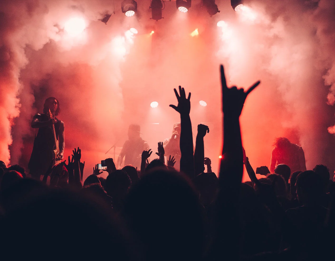 Concert with crowd and performer in red lighting